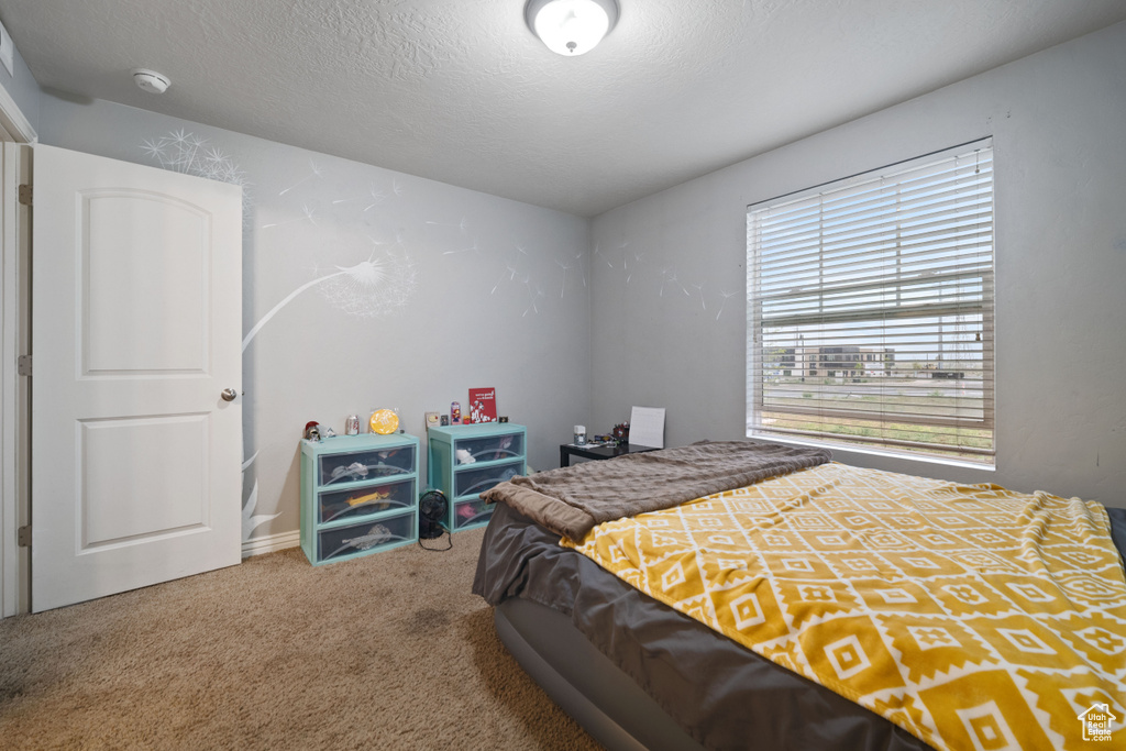 Bedroom with a textured ceiling and carpet flooring