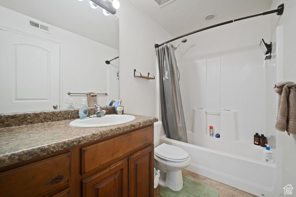 Full bathroom with toilet, shower / bath combination with curtain, visible vents, tile patterned floors, and vanity