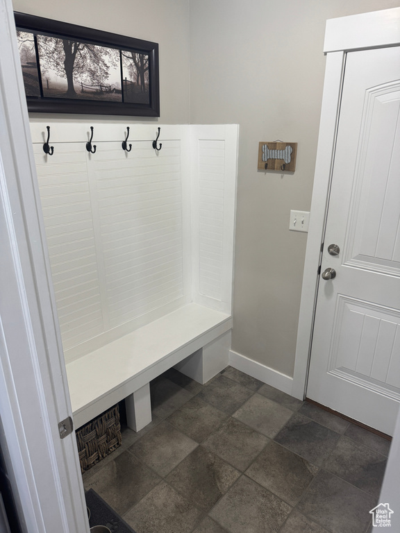 Mudroom featuring baseboards and stone finish flooring