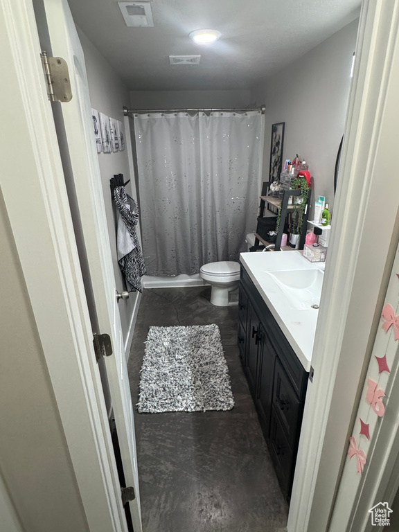 Bathroom with toilet, curtained shower, visible vents, concrete flooring, and vanity