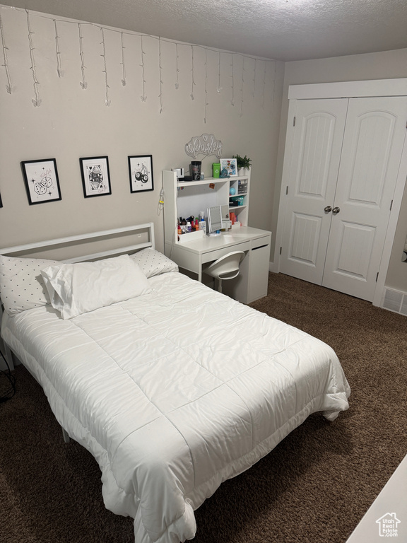 Bedroom featuring dark carpet and a closet