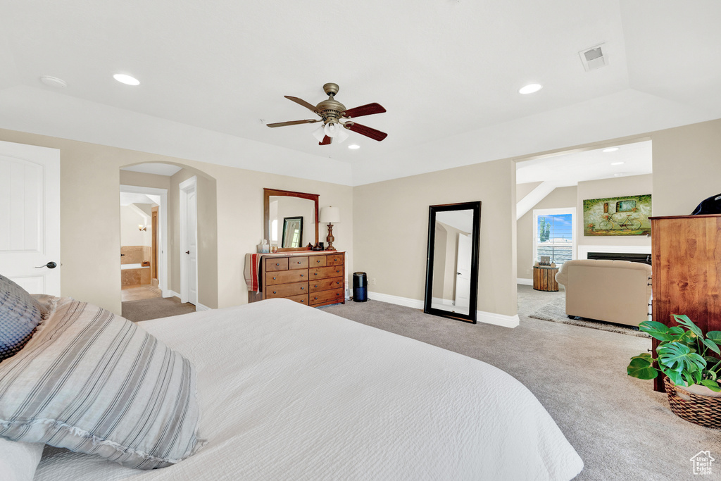 Bedroom featuring recessed lighting, baseboards, visible vents, arched walkways, and light colored carpet