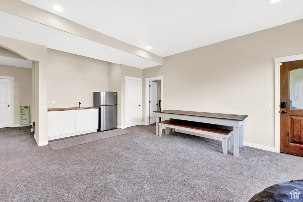 Unfurnished living room with baseboards, recessed lighting, carpet floors, and arched walkways