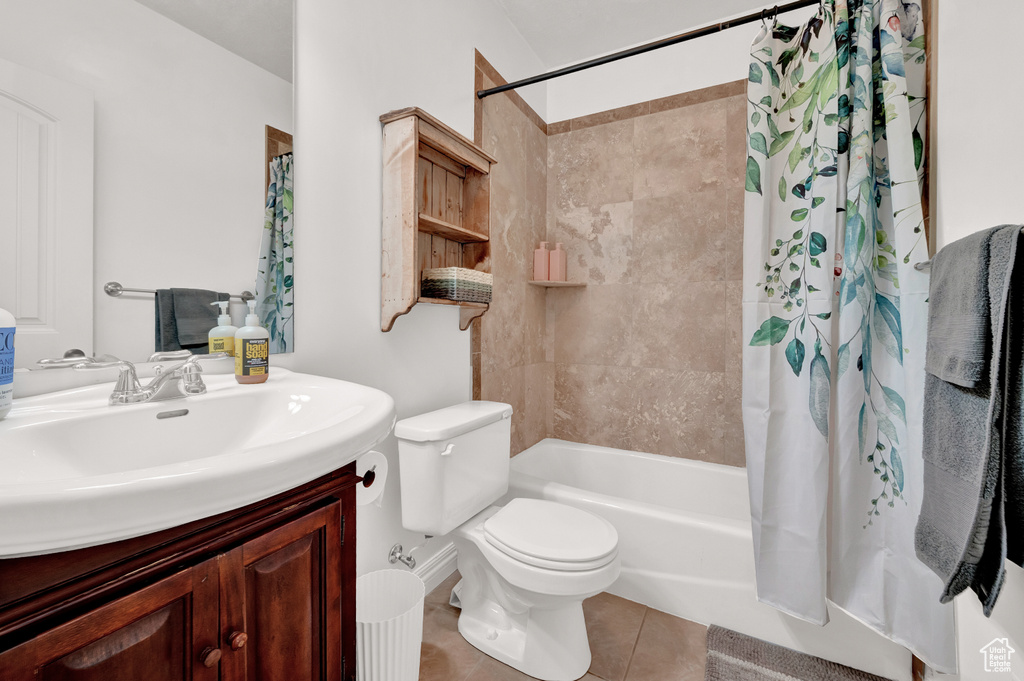 Full bath with vanity, shower / tub combo with curtain, toilet, and tile patterned floors