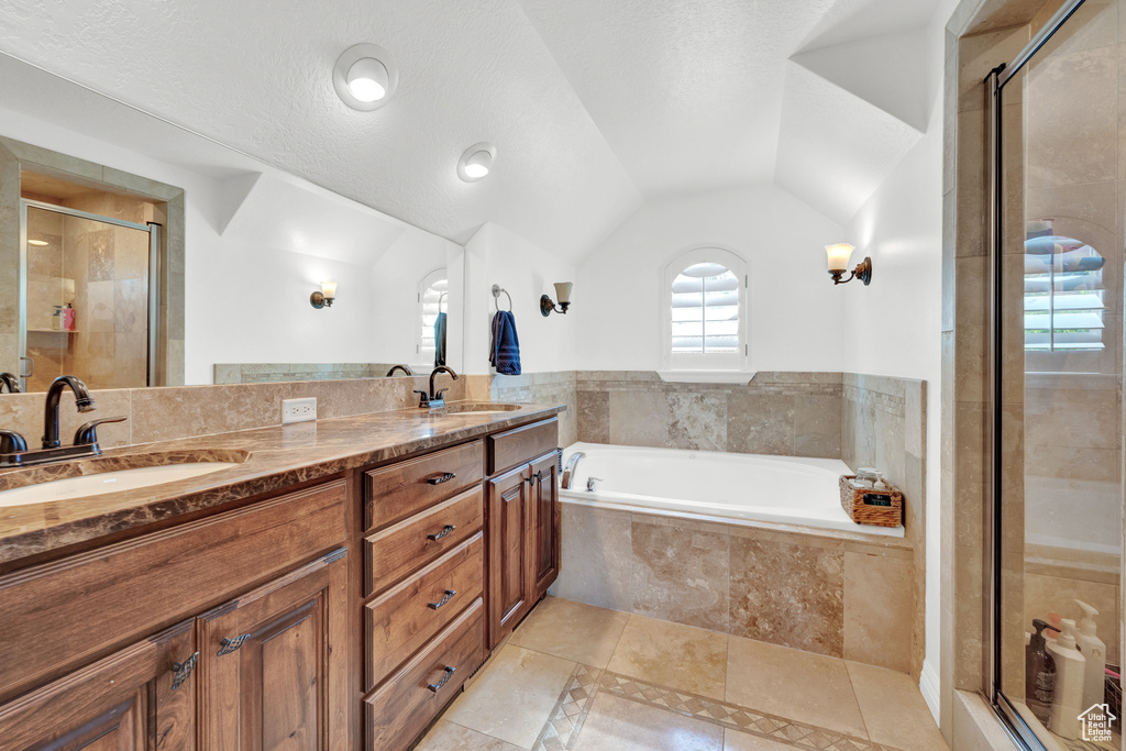Bathroom featuring a shower stall, a garden tub, and a sink