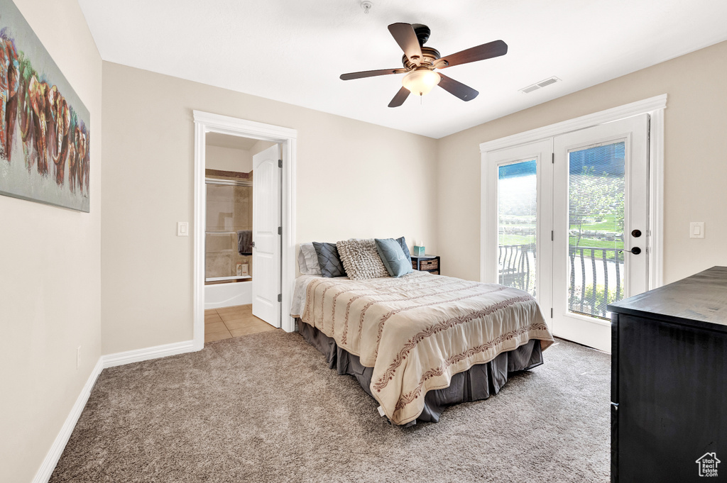 Bedroom with light carpet, visible vents, baseboards, ensuite bath, and access to outside