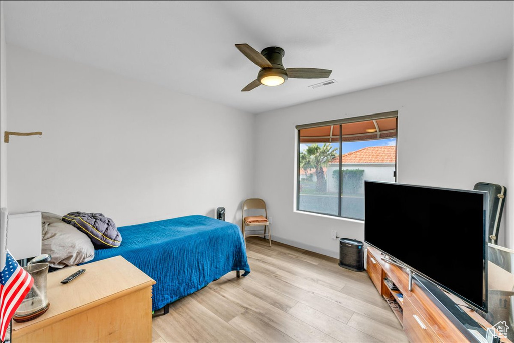 Bedroom with light wood-style flooring, baseboards, a ceiling fan, and visible vents