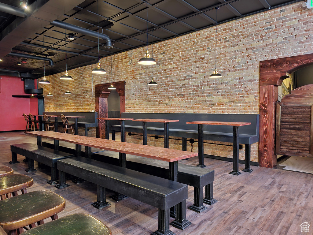 Dining room with brick wall and wood finished floors