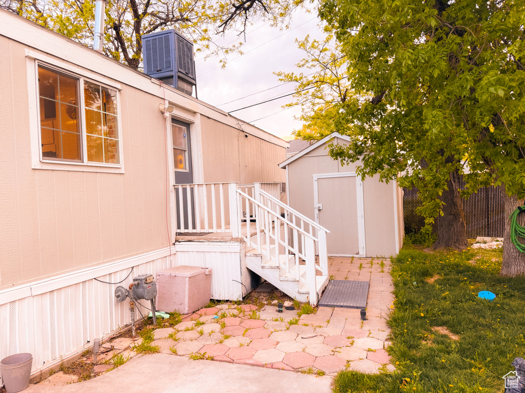 Exterior space featuring cooling unit, an outbuilding, and a shed