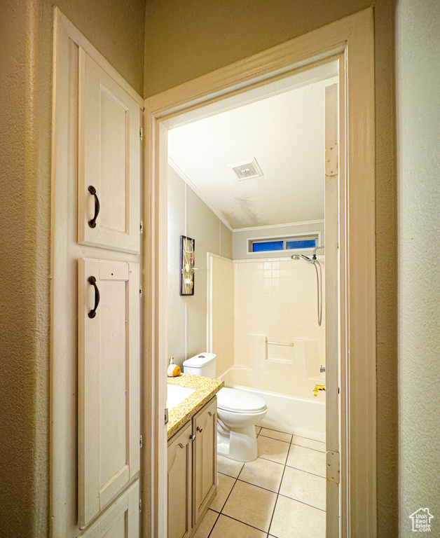 Bathroom with toilet, visible vents, tile patterned flooring, vanity, and washtub / shower combination