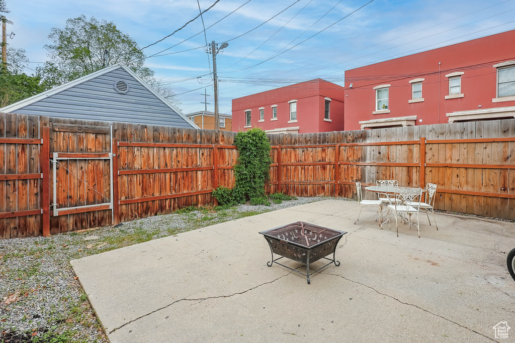 View of patio / terrace featuring an outdoor fire pit, a gate, and a fenced backyard