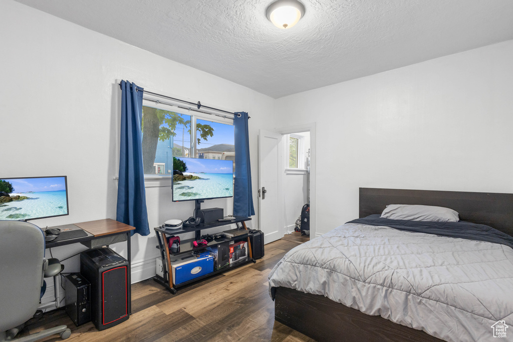 Bedroom featuring a textured ceiling and wood finished floors