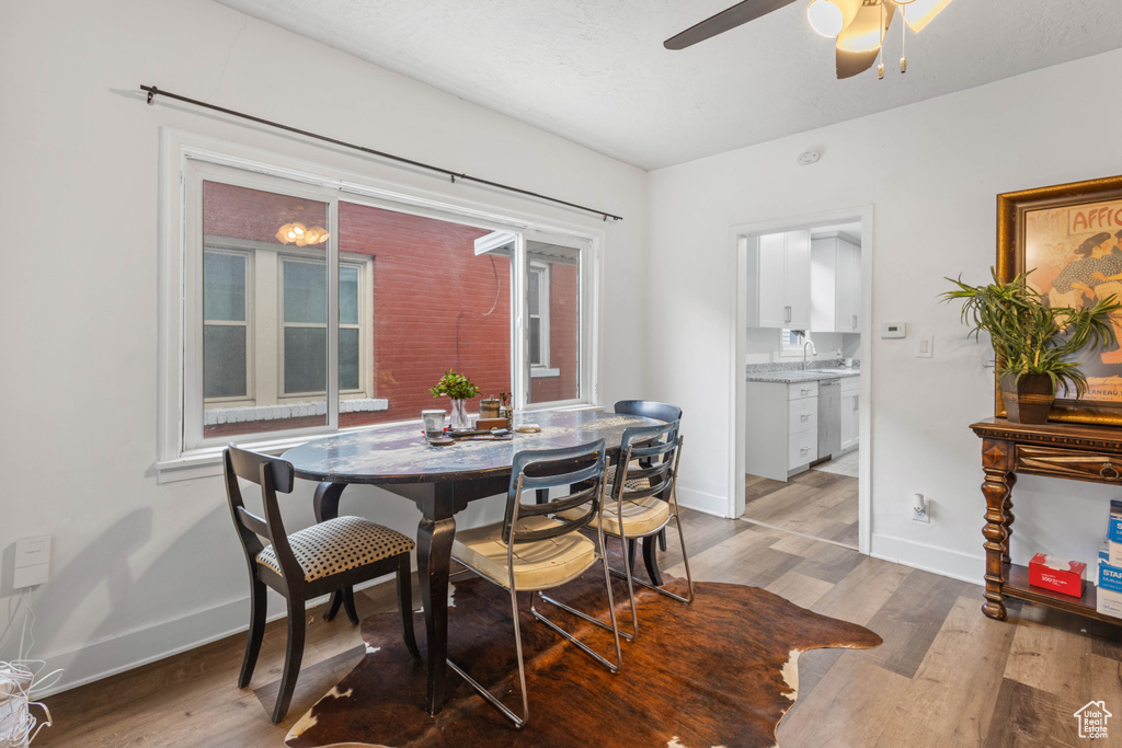 Dining room with baseboards, light wood finished floors, and a ceiling fan