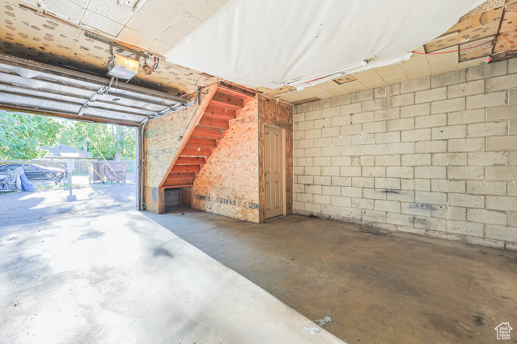 Garage with a garage door opener and concrete block wall