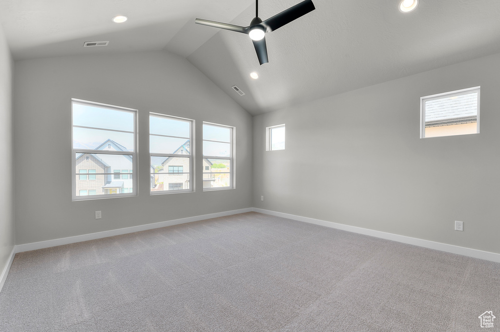Spare room with ceiling fan, lofted ceiling, baseboards, light carpet, and recessed lighting
