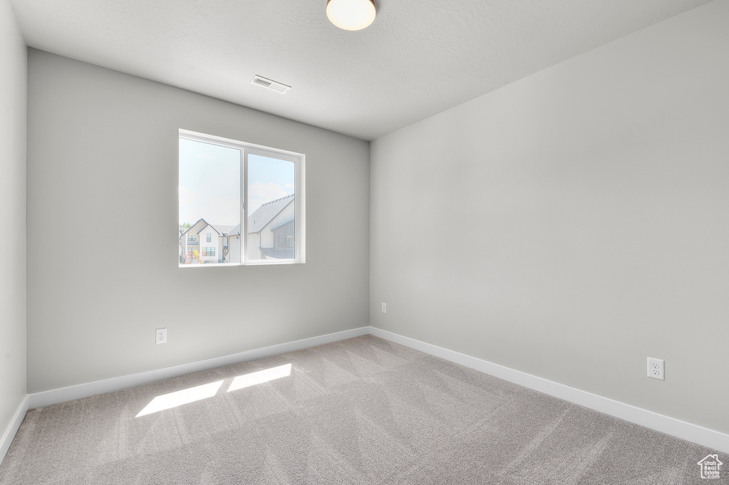 Spare room featuring carpet floors and baseboards