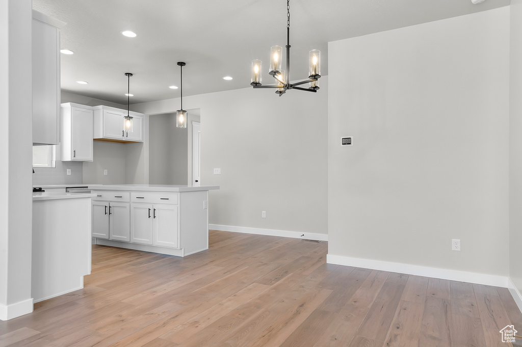 Kitchen featuring a chandelier, light wood finished floors, light countertops, baseboards, and recessed lighting