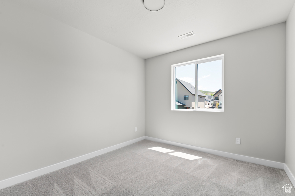 Carpeted spare room with baseboards