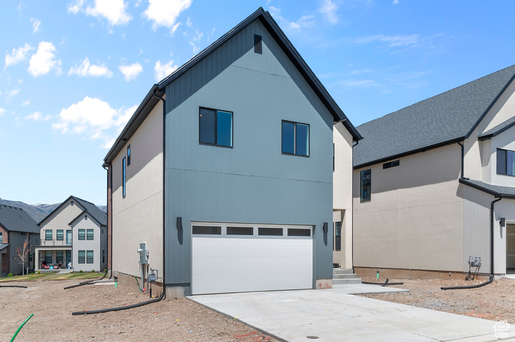 Back of house with a garage and driveway