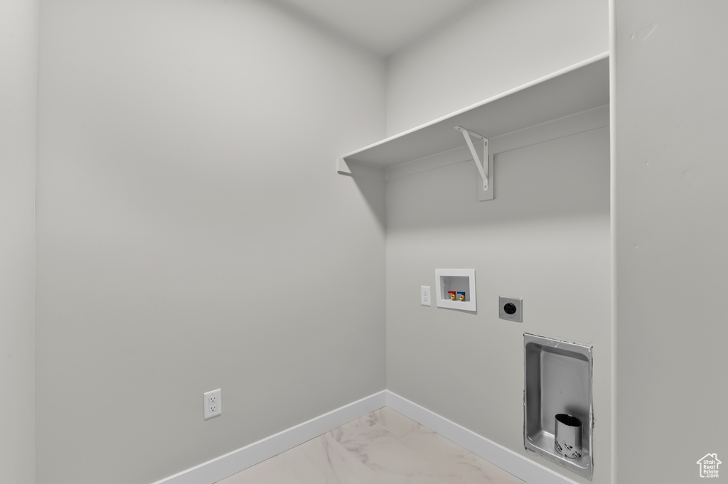 Washroom featuring washer hookup, electric dryer hookup, light marble finish floors, and baseboards