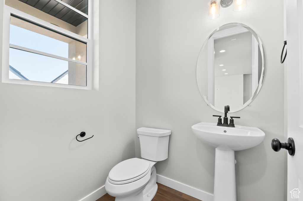 Bathroom with baseboards, toilet, and wood finished floors
