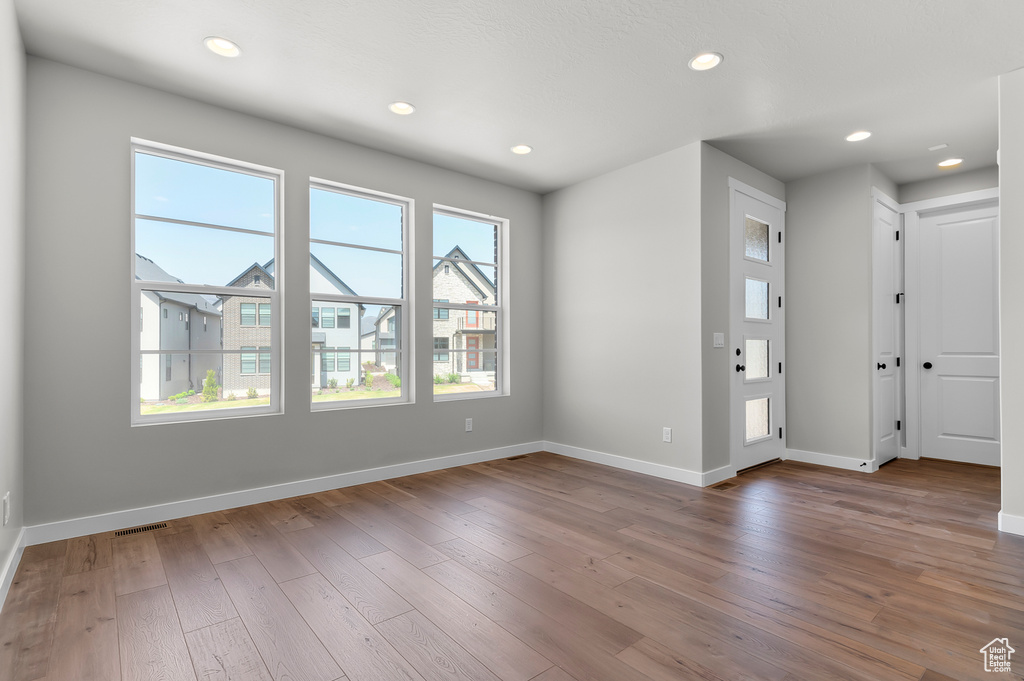 Empty room with wood-type flooring, baseboards, and recessed lighting
