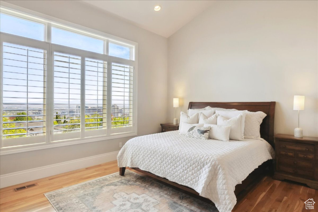 Bedroom with lofted ceiling, recessed lighting, baseboards, visible vents, and wood finished floors