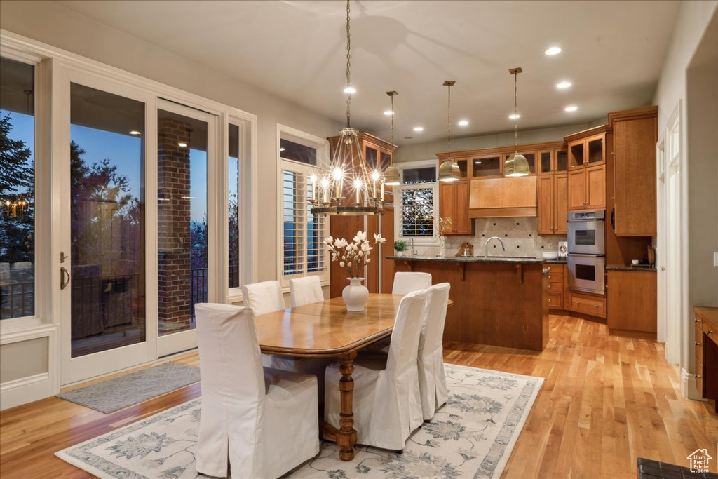 Dining room featuring an inviting chandelier, light wood-type flooring, and recessed lighting