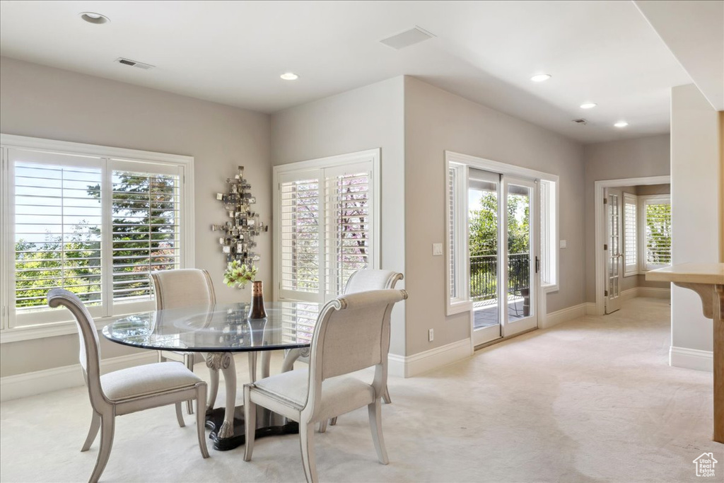 Dining room with light carpet, baseboards, and recessed lighting