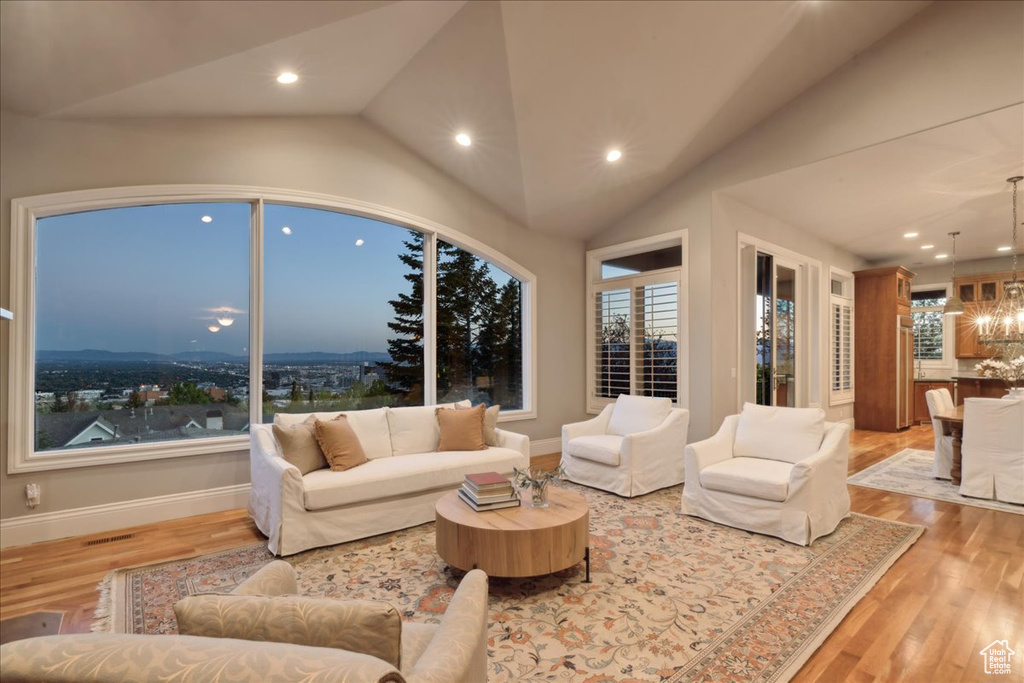 Living area featuring vaulted ceiling, a chandelier, recessed lighting, and wood finished floors