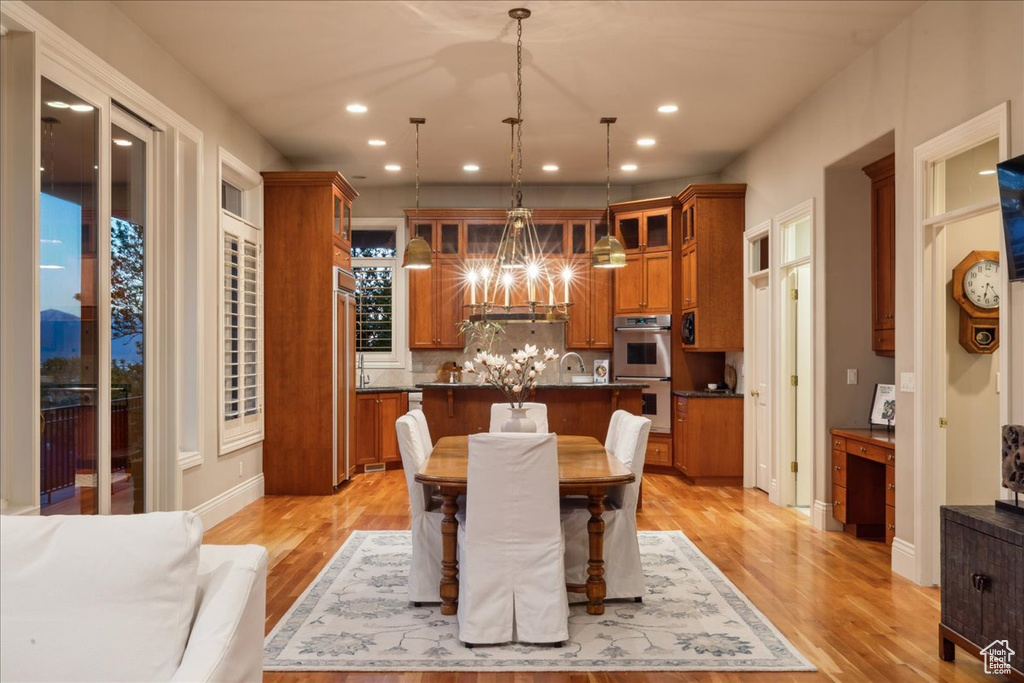 Dining area with recessed lighting, light wood-type flooring, and a notable chandelier