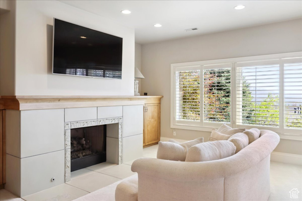 Living room with a fireplace, baseboards, visible vents, and recessed lighting