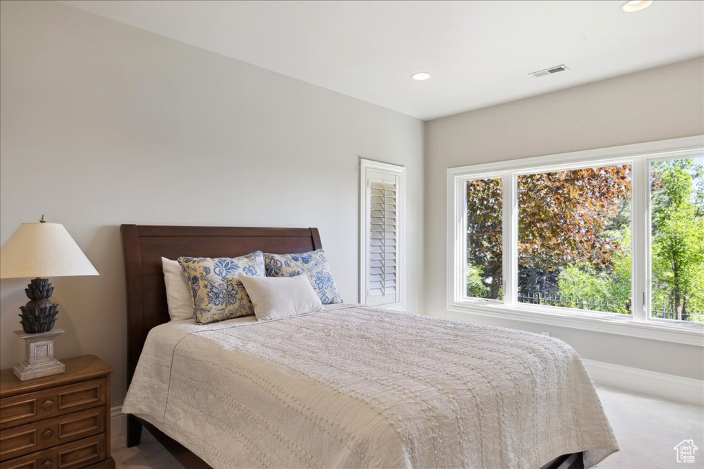 Carpeted bedroom with recessed lighting, baseboards, visible vents, and multiple windows
