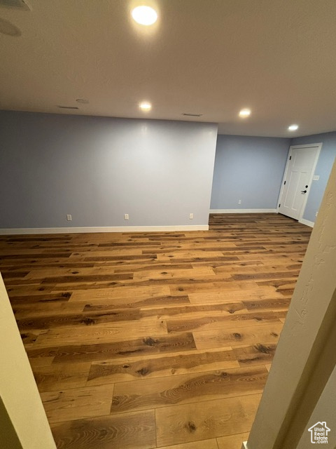 Finished basement with wood finished floors, baseboards, and recessed lighting