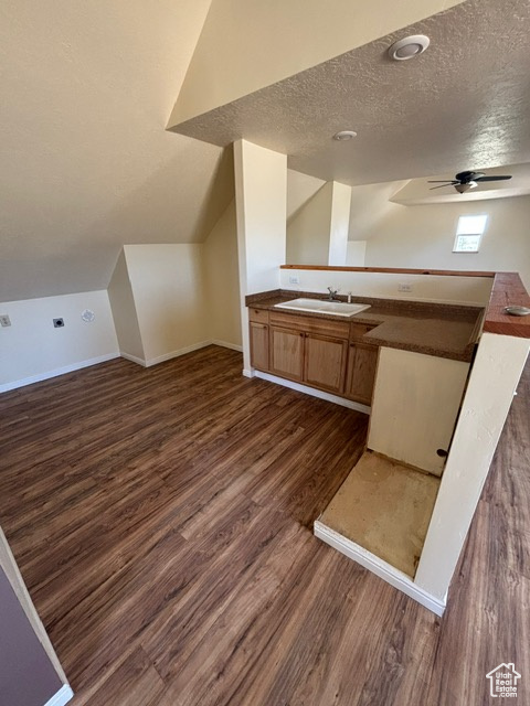 Bathroom with wood finished floors, a textured ceiling, a ceiling fan, baseboards, and vanity