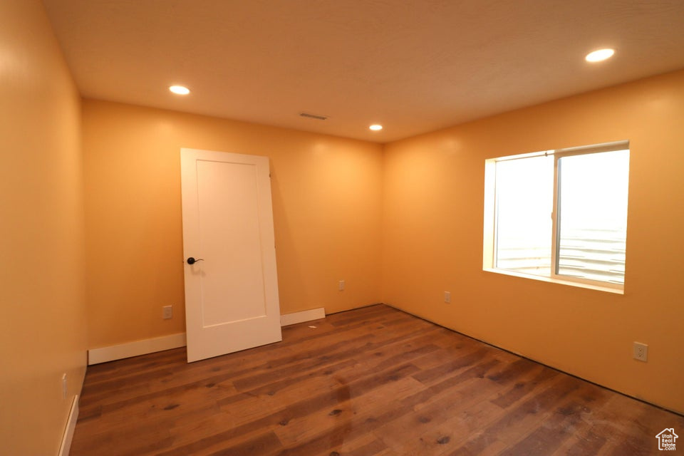 Unfurnished room with wood finished floors and recessed lighting