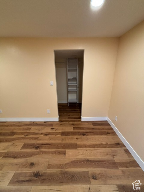 Unfurnished room with wood finished floors and baseboards