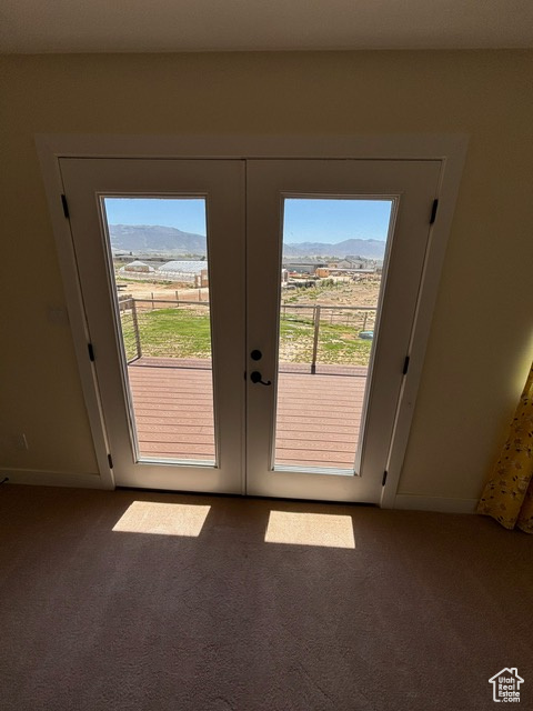 Doorway to outside featuring carpet flooring, french doors, and a mountain view