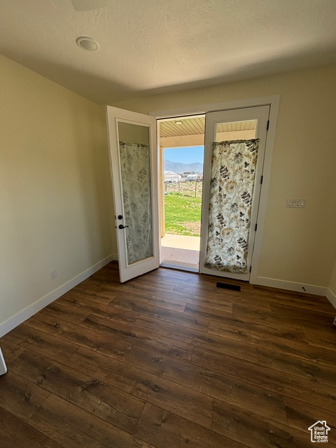 Foyer entrance featuring dark wood-style flooring and baseboards