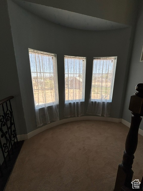 Spare room featuring healthy amount of natural light, carpet, and baseboards