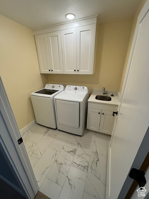 Washroom with cabinet space, separate washer and dryer, light marble finish flooring, baseboards, and recessed lighting