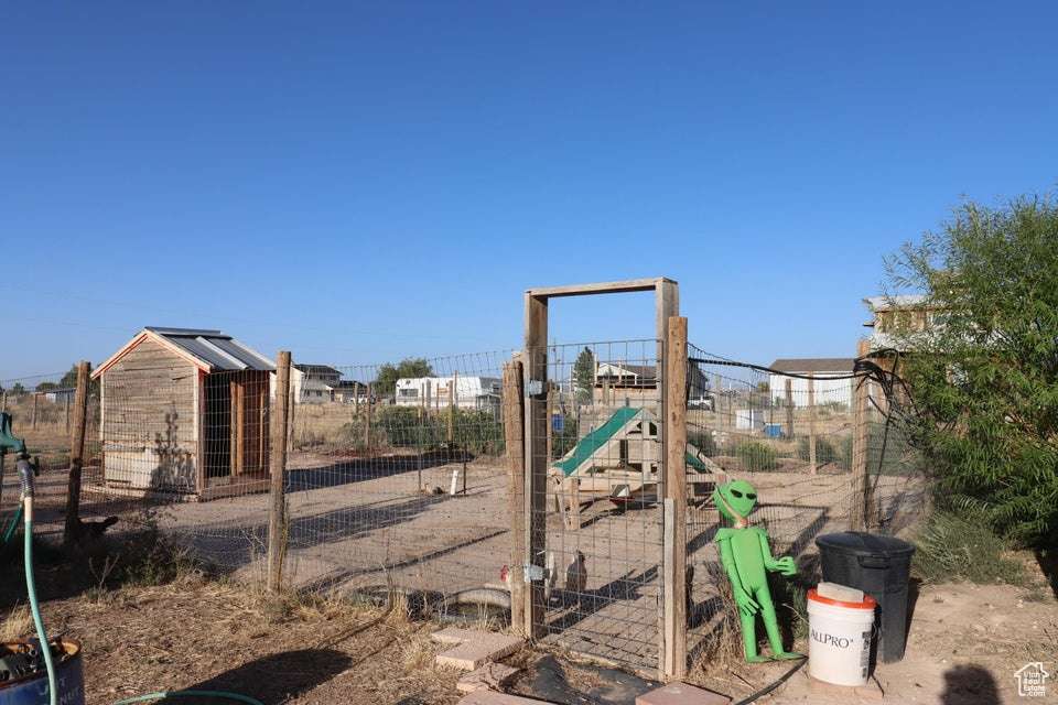 View of playground with exterior structure, an outdoor structure, and fence