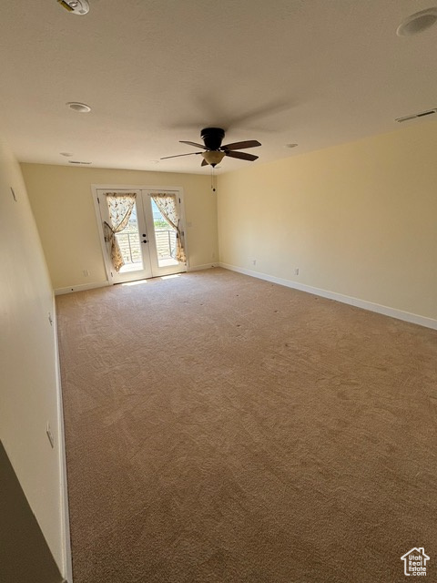 Spare room with french doors, light carpet, ceiling fan, and baseboards