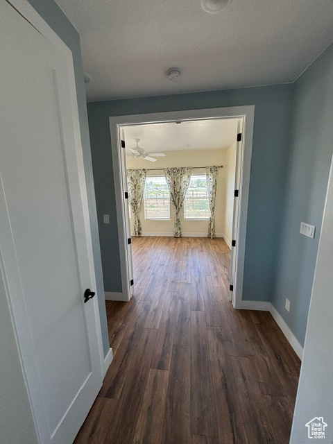 Corridor with dark wood finished floors and baseboards