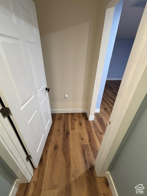 Corridor with wood finished floors and baseboards