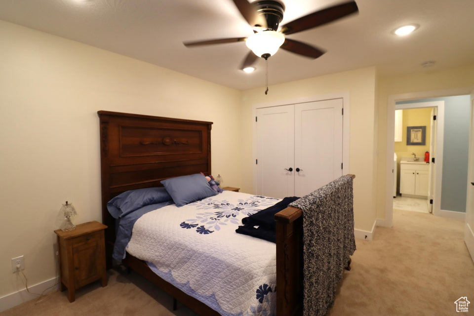 Bedroom featuring a closet, light carpet, and baseboards