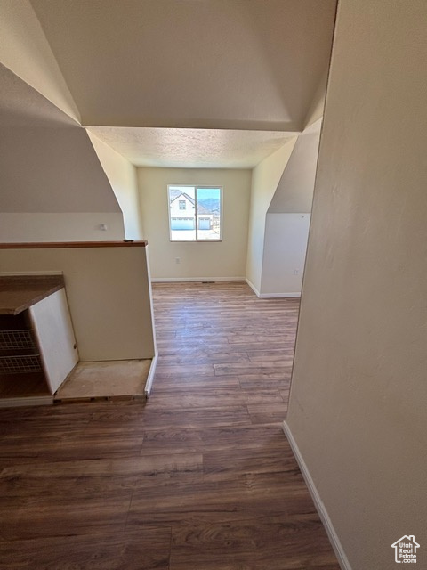 Additional living space featuring wood finished floors and baseboards