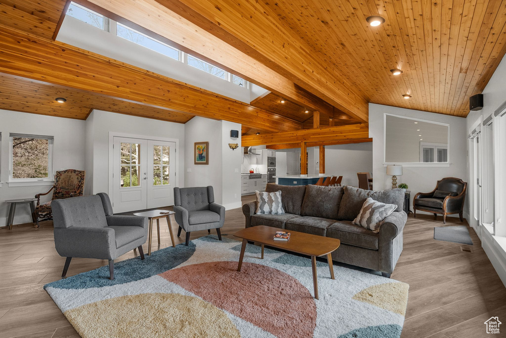 Living area with recessed lighting, baseboards, wood ceiling, wood finished floors, and vaulted ceiling with skylight
