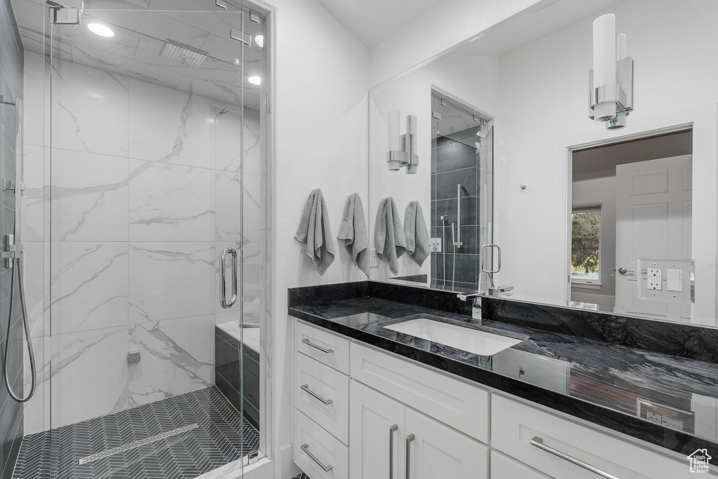 Bathroom with vanity and a marble finish shower