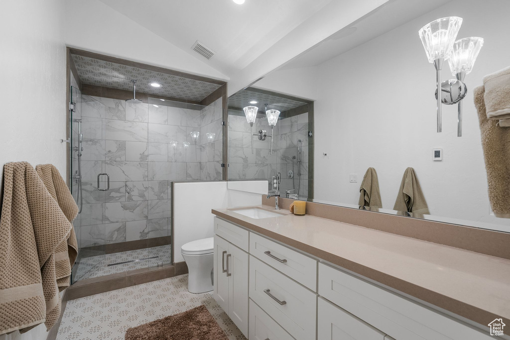 Bathroom featuring lofted ceiling, toilet, visible vents, a shower stall, and vanity